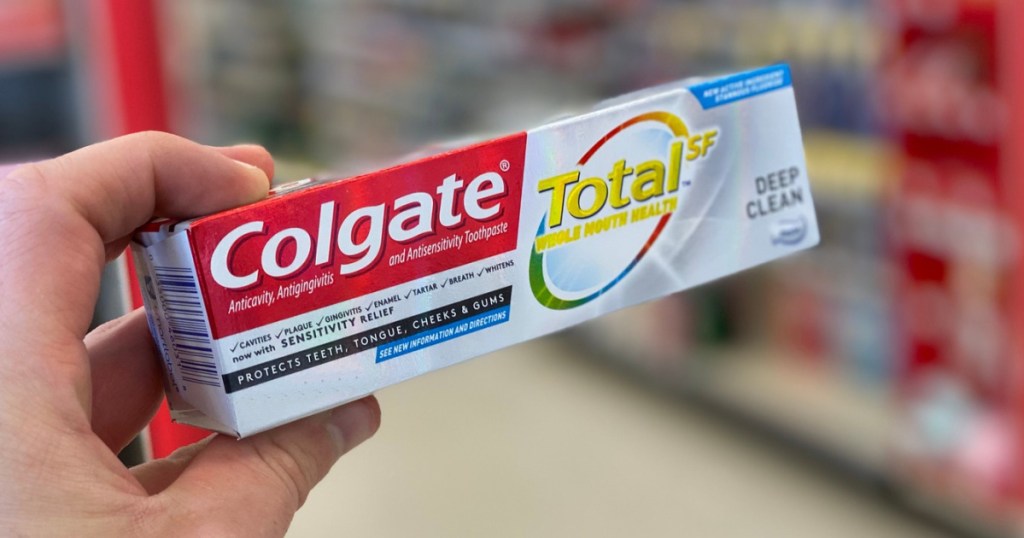 hand holding colgate total toothpaste