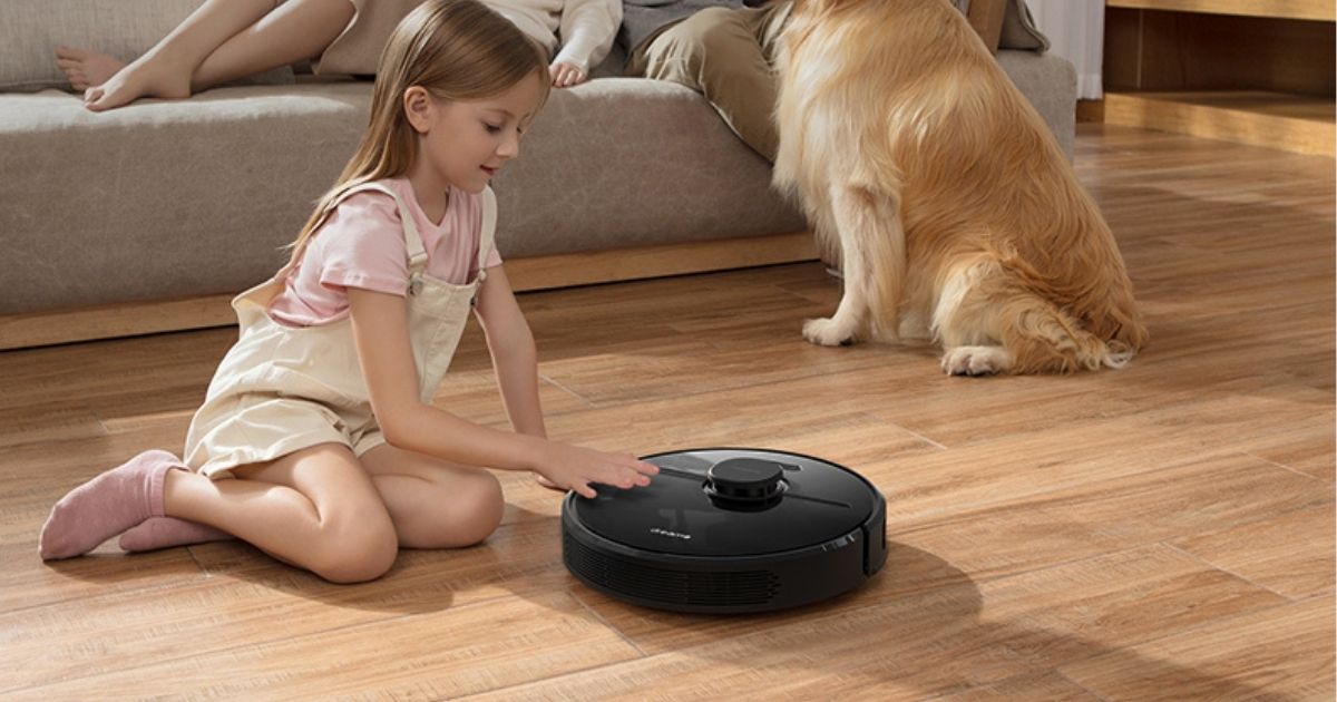 kid on the floor touching robot vacuum 