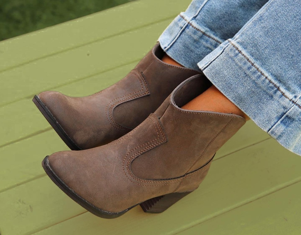person wearing pair of brown western style boots