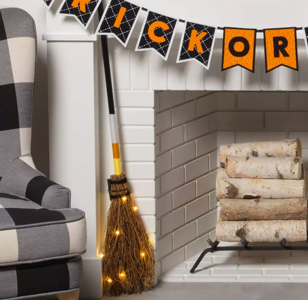 light up halloween broom next to a fireplace