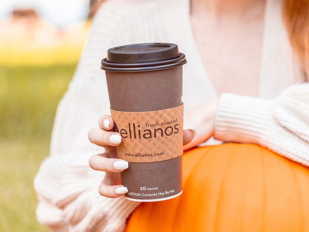 holding a disposable coffee cup with a lid