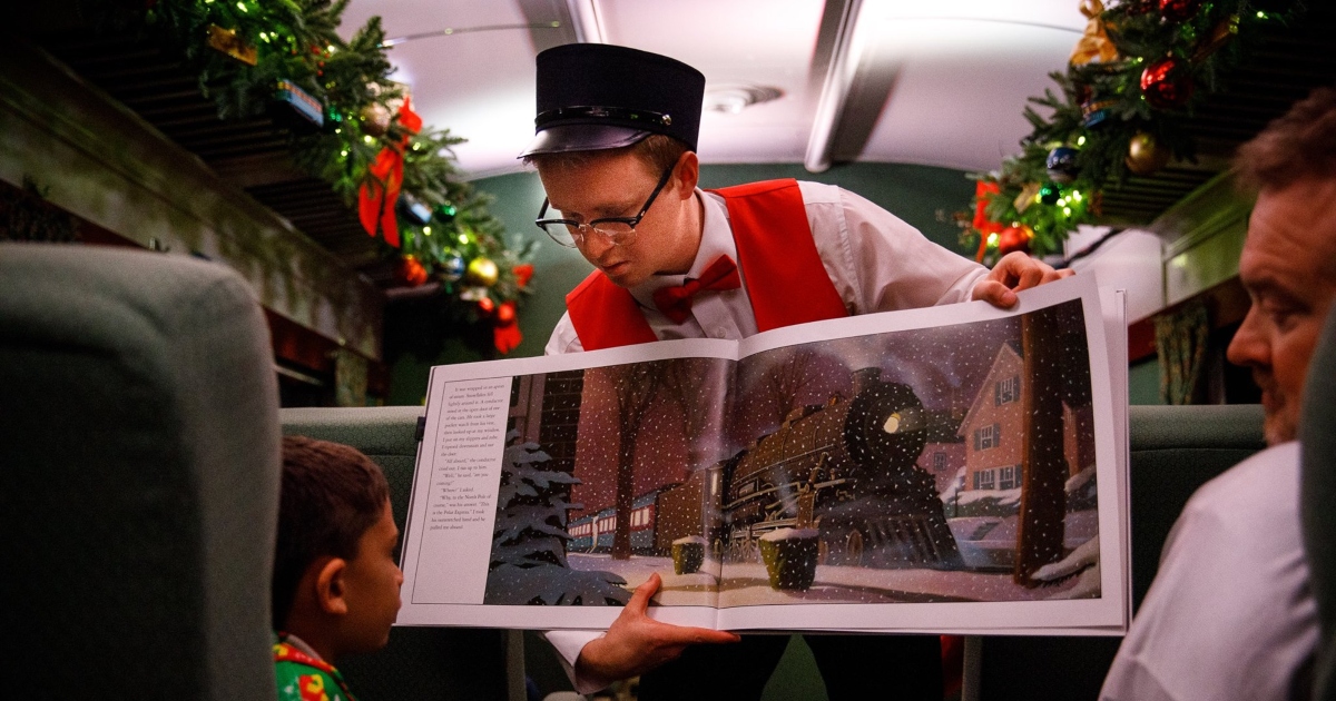 man reading The Polar Express on train