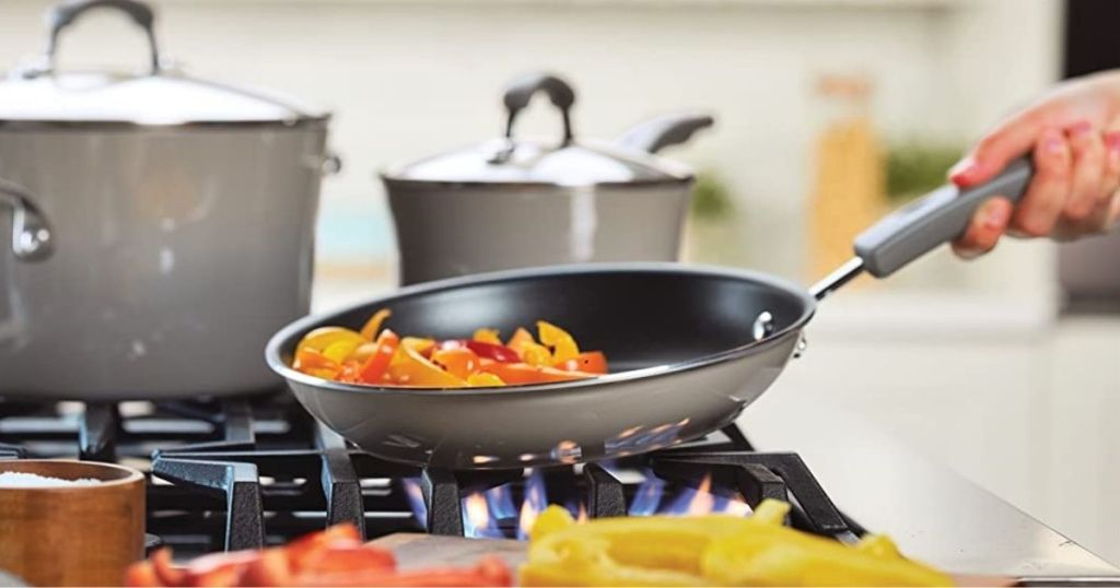 hand with pan filled with vegetables