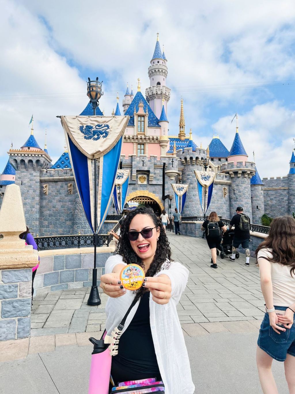 woman holding up first time sticker at disneyland