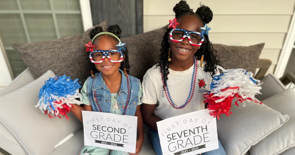 two adorable girls with back to school signs
