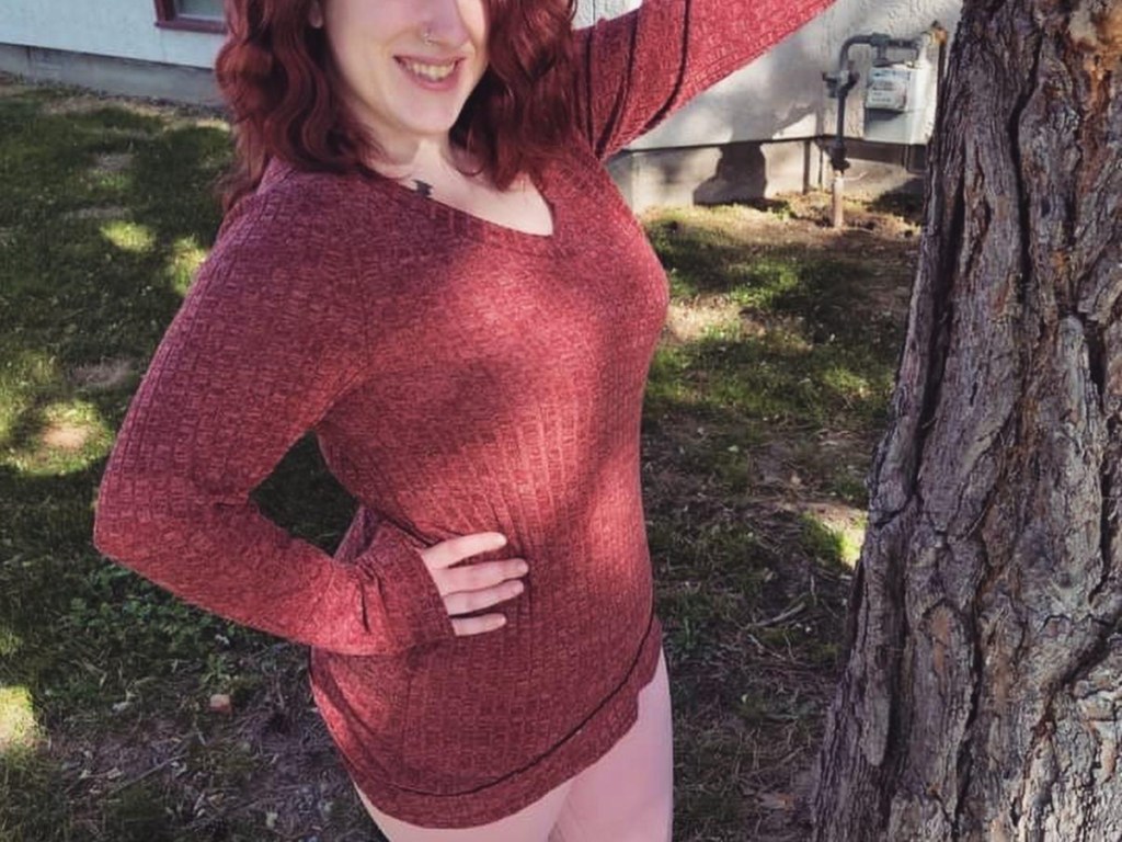 woman leaning on tree trunk