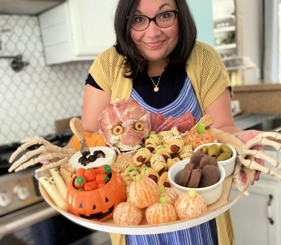 woman holding a halloween snack board