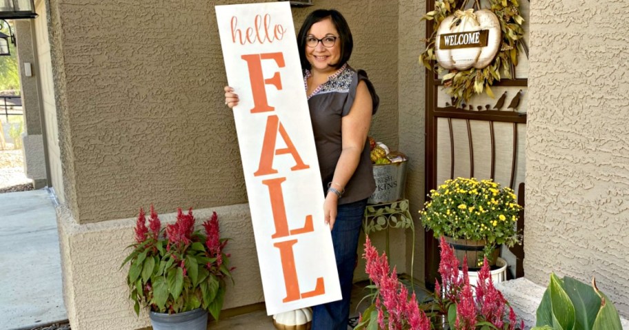 Woman holding a DIY holiday porch sign
