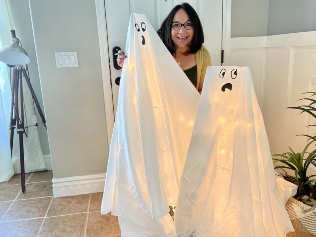 woman making tomato cage ghost decorations