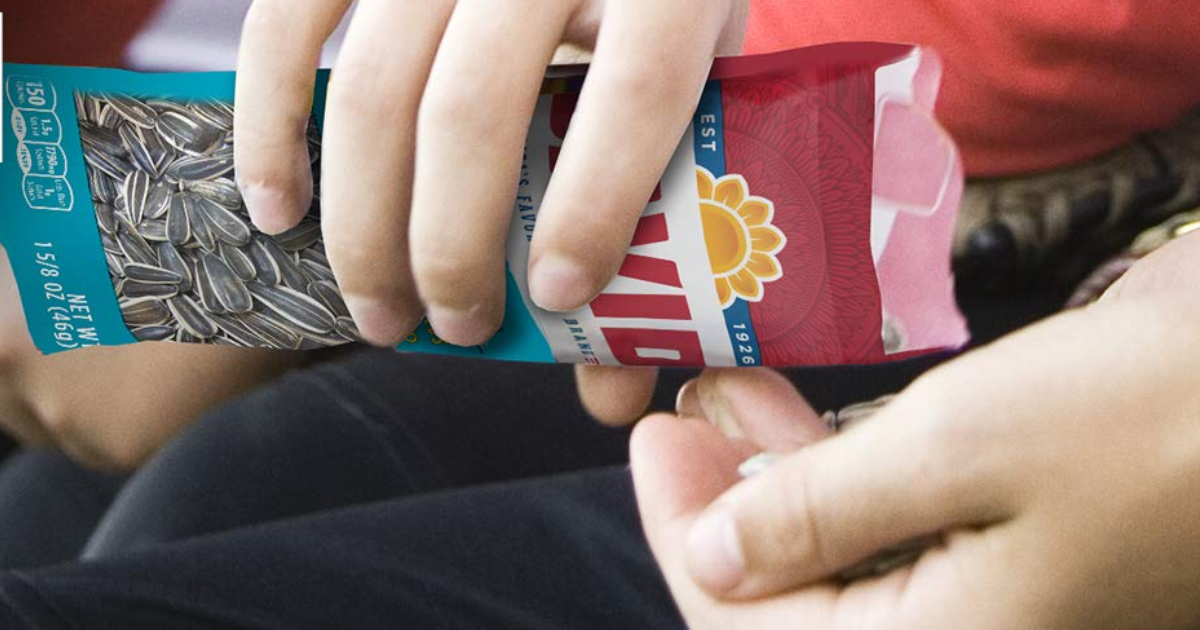 hand pouring a bag of david sunflower seeds into their opposite hand