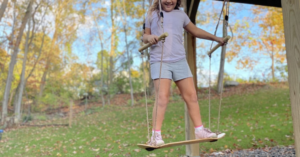 girl on a wooden skateboard swing