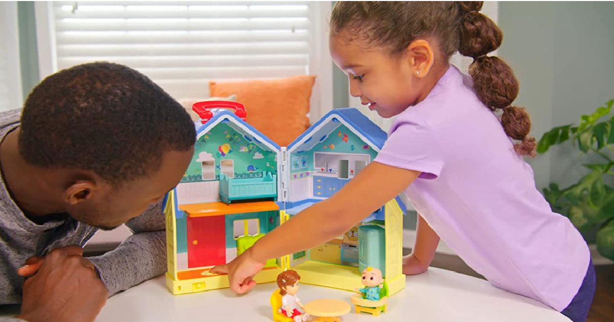 girl and man in front of toy house