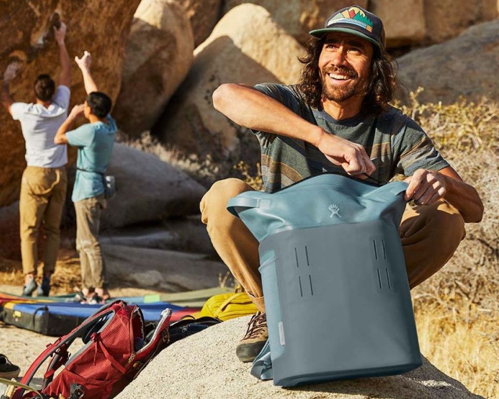 man zipping a Hydro Flask cooler closed