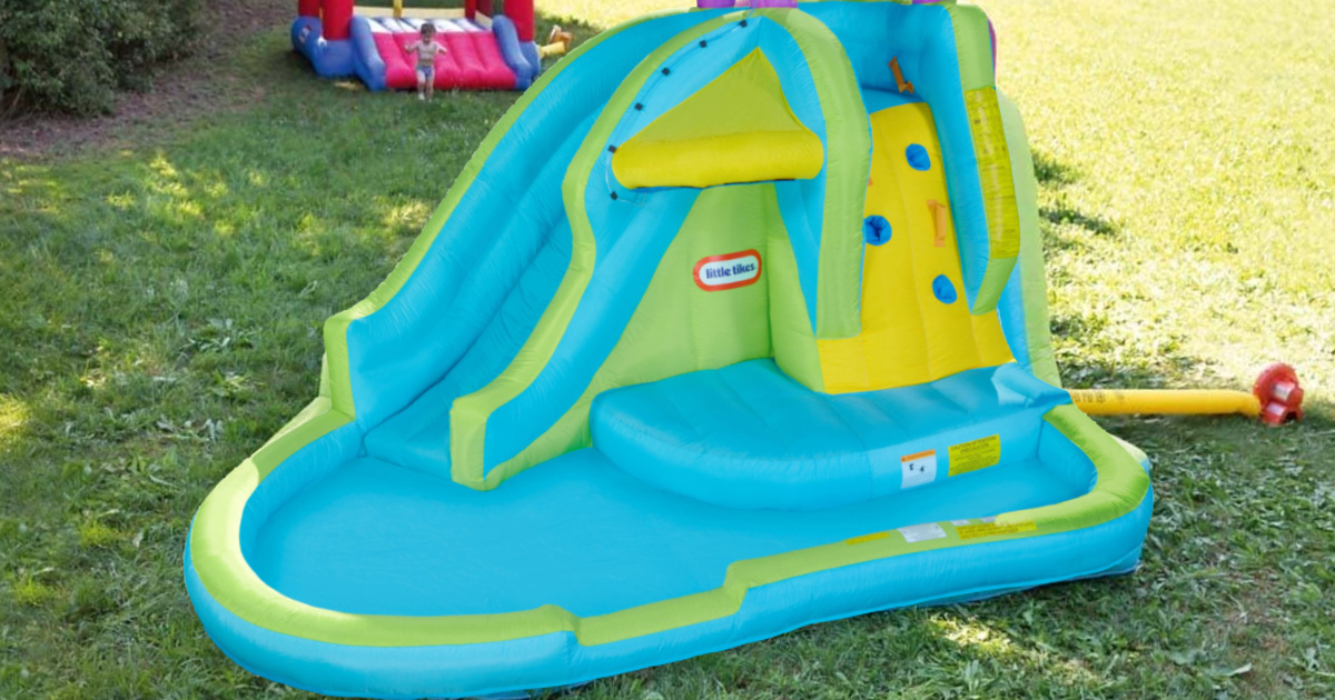 kids inflatable little tikes water slide set up in a backyard