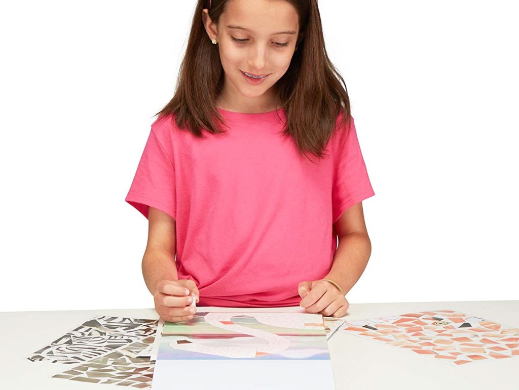 girl completeing sticker pad activity book