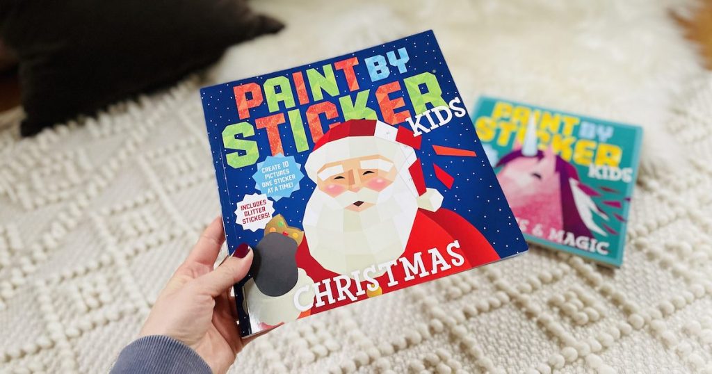 hand holding santa christmas paint by sticker book