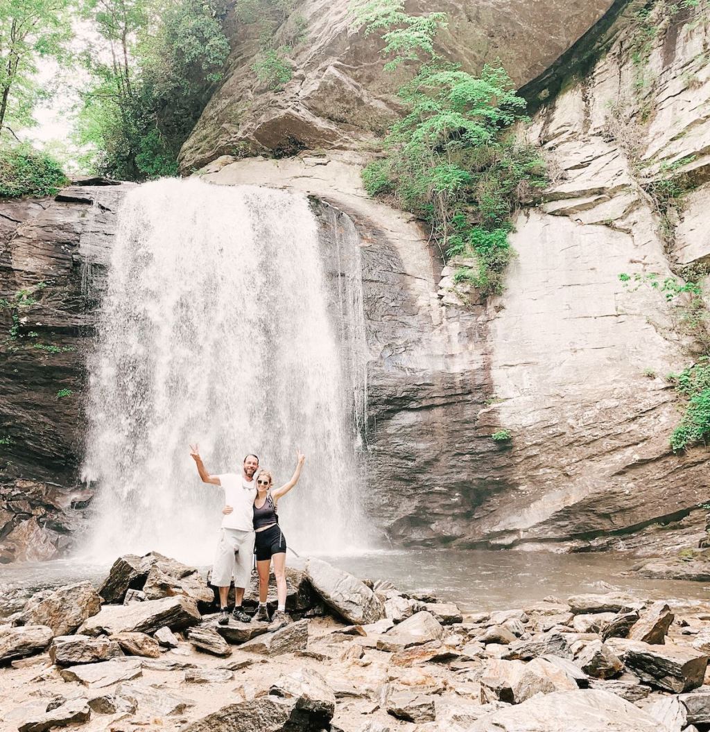 two people hugging in front of huge waterfall
