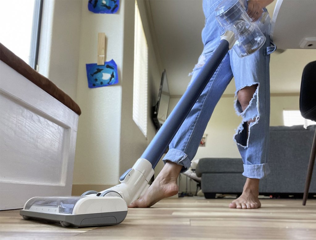 woman using stick vaucum house cleaning tips