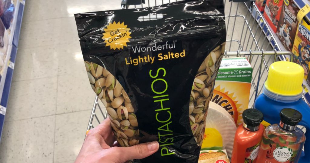 hand holding black bag of pistachios 