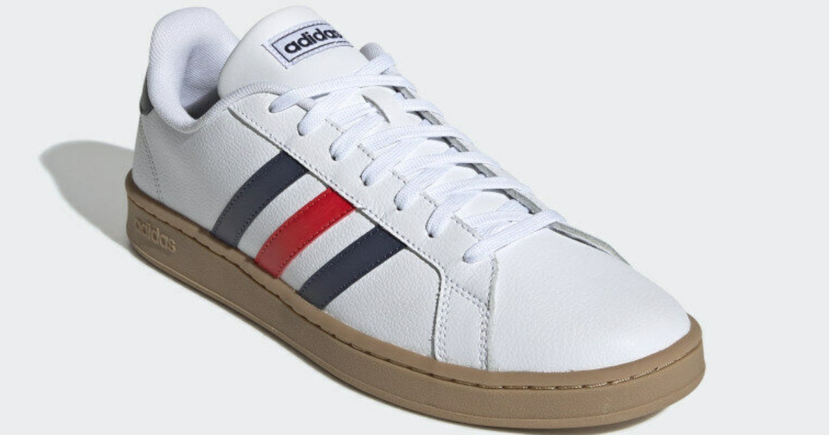 a white adidas shoe with three colored stripes