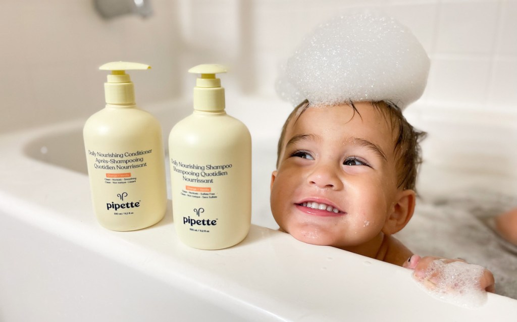 boy with bubbles on head and pipette baby products on tub