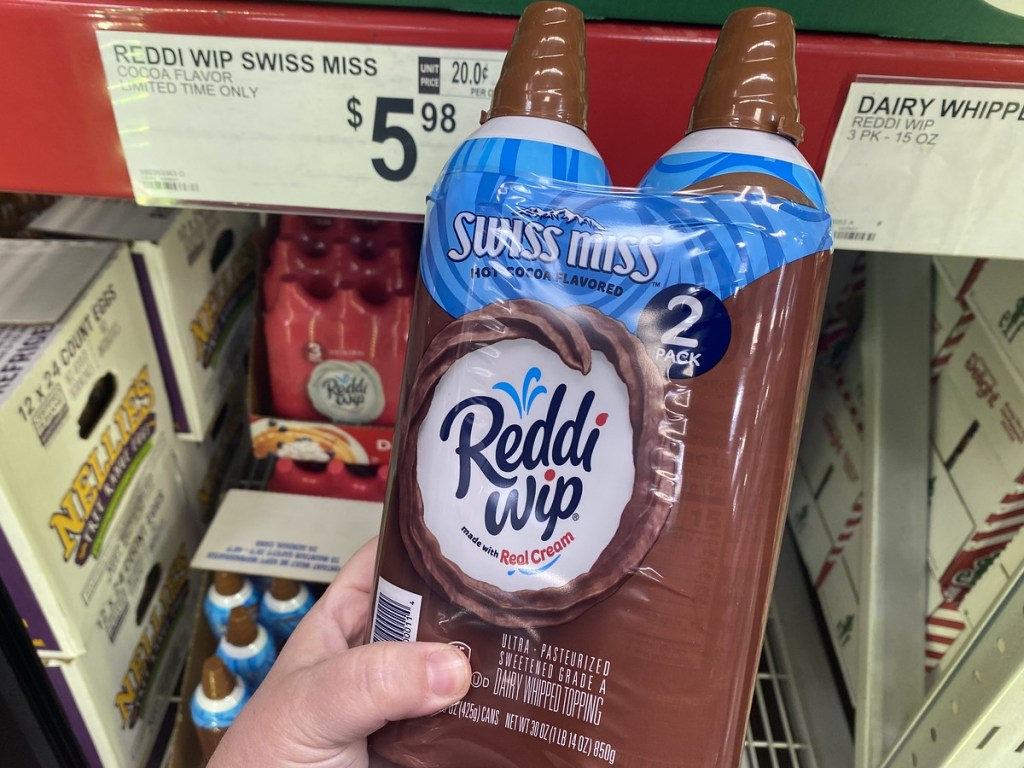 holding a 2-pack of Swiss Miss Reddi Whip
