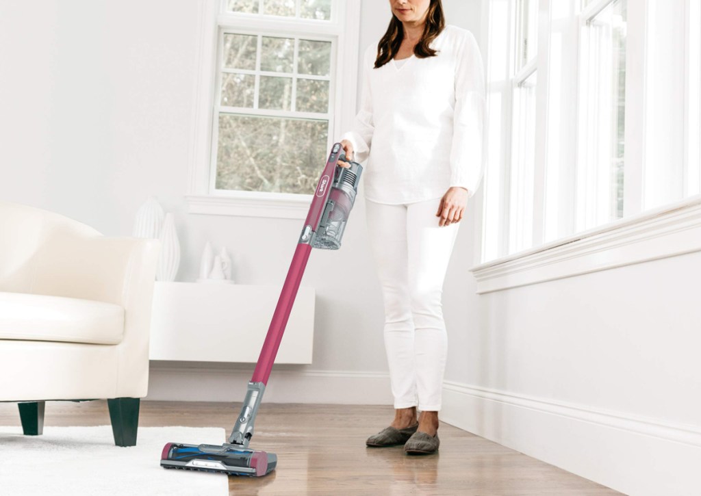 woman holding shark stick vacuum