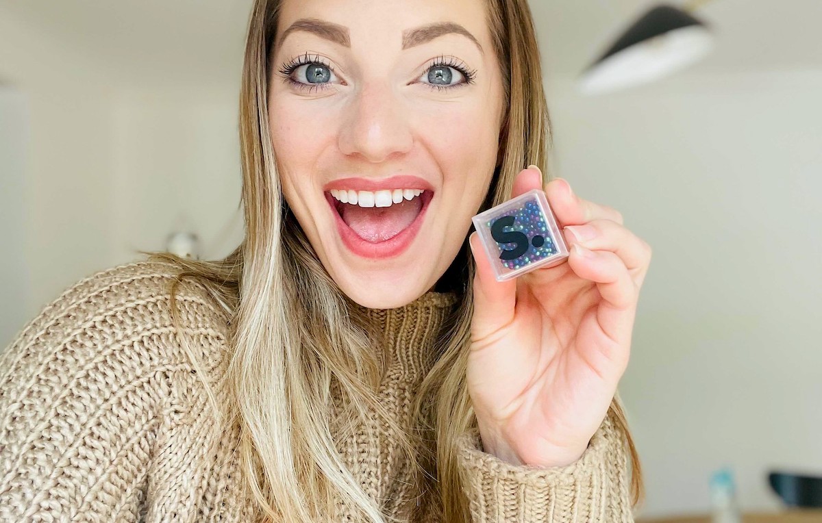 woman holding up clear cube 