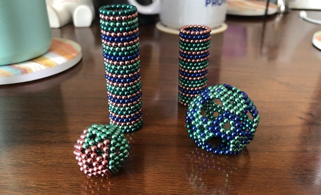 magnetic balls on wood table in different shapes