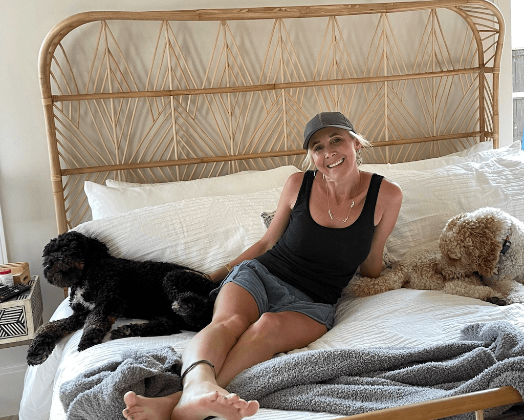 woman on bed with two dogs 