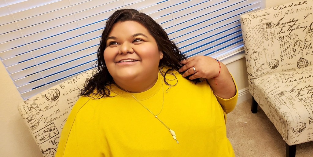 woman wearing yellow sweatshirt and gold necklace 