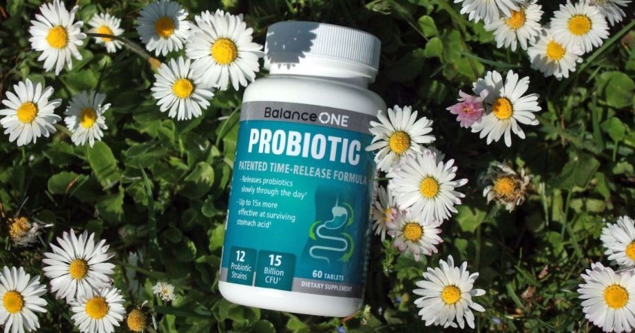 bottle of probiotics laying in flowers