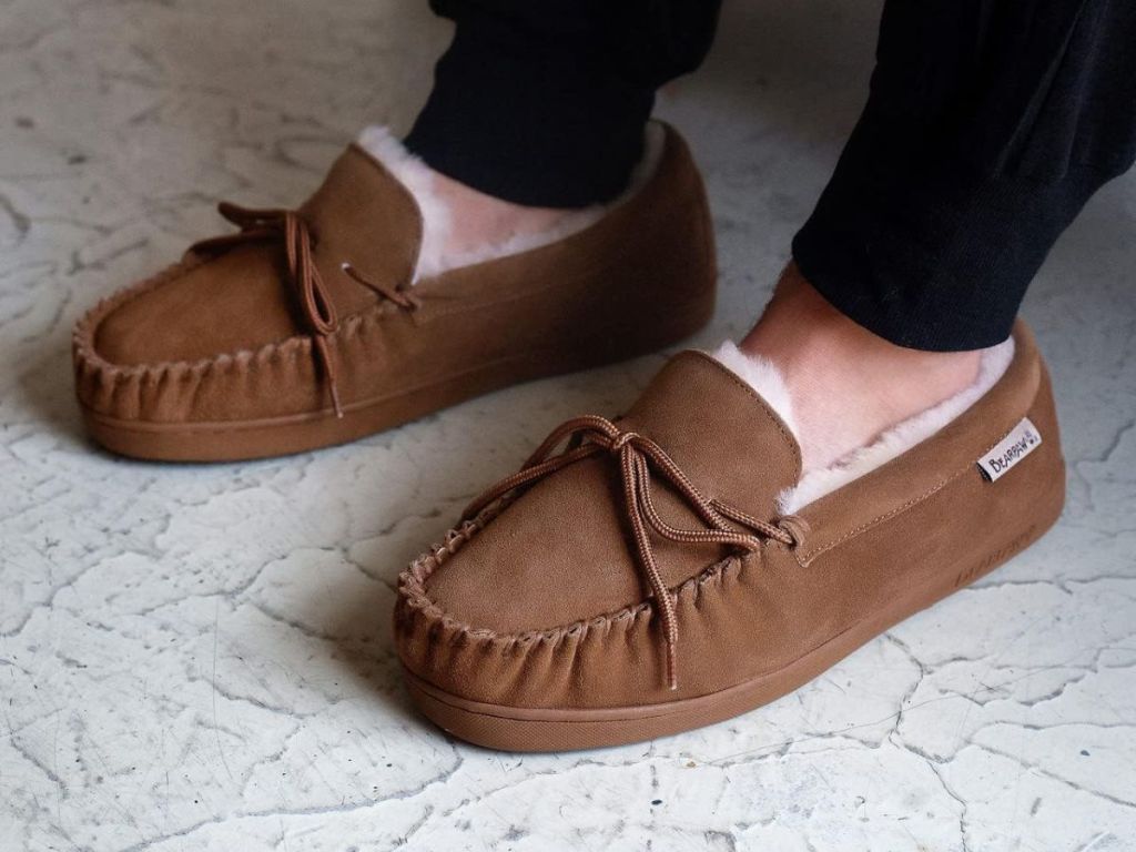 A man wearing Bearpaw Moccasin II Slippers