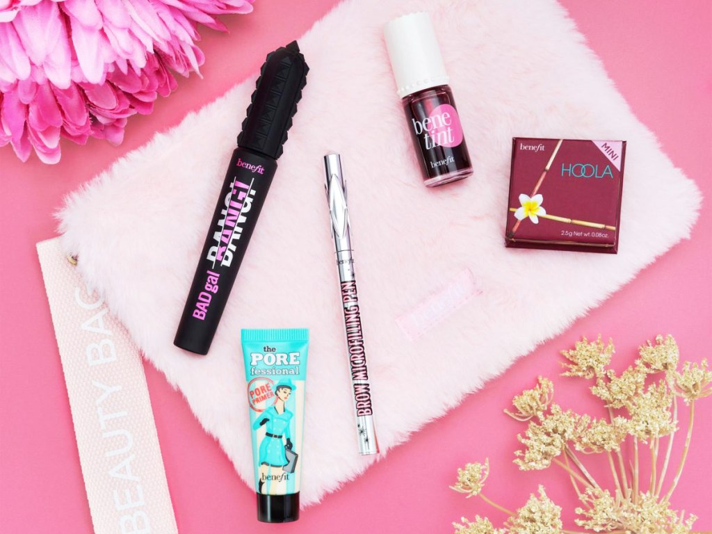 benefit brow pen, lip tint, mascara, primer, bronzer, and fuzzy pink makeup bag