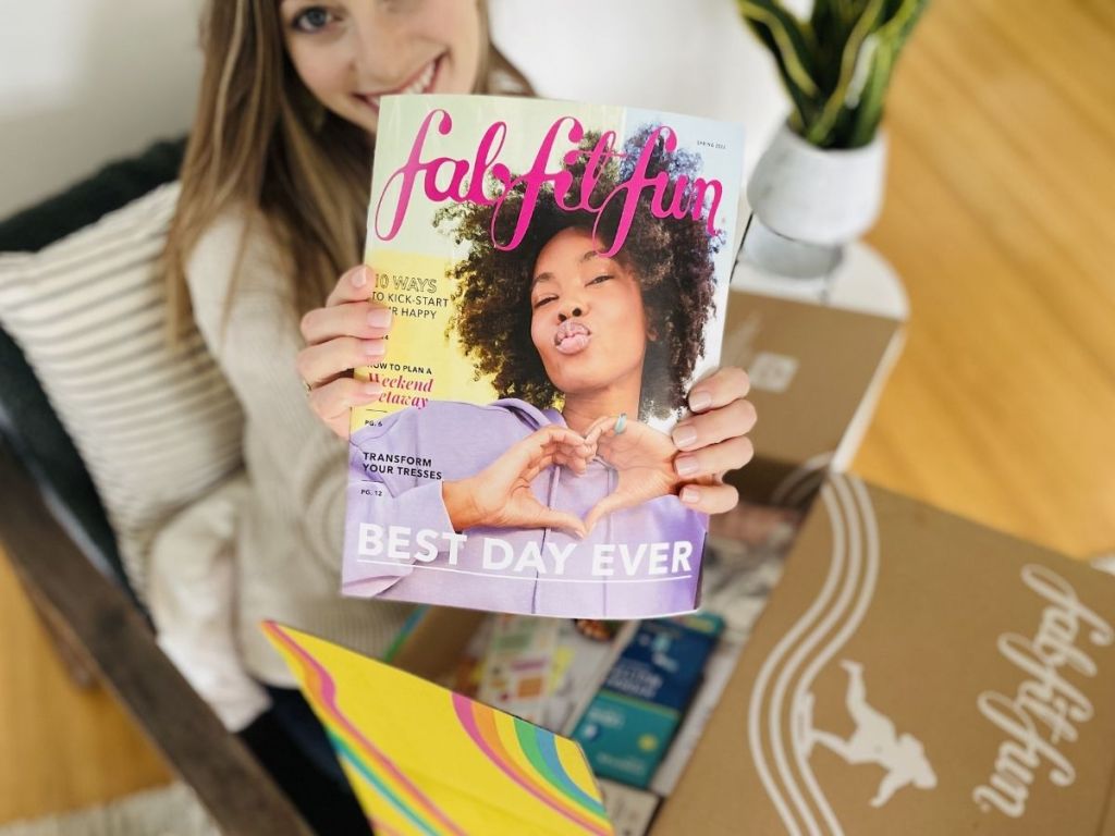 woman holding up fabfitfun magazine