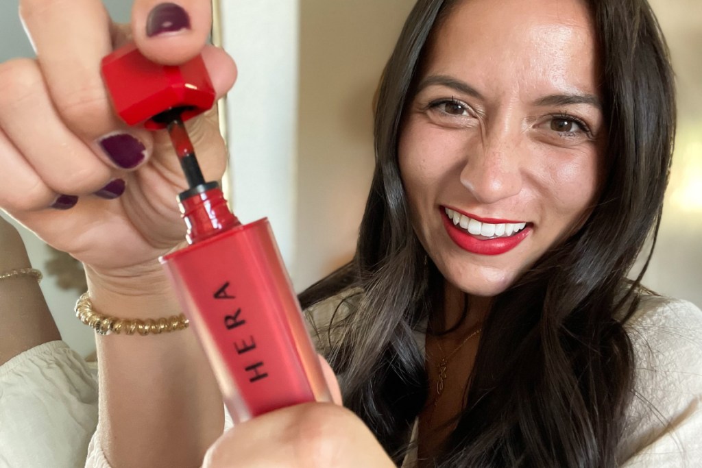 woman opening HERA lip tint red