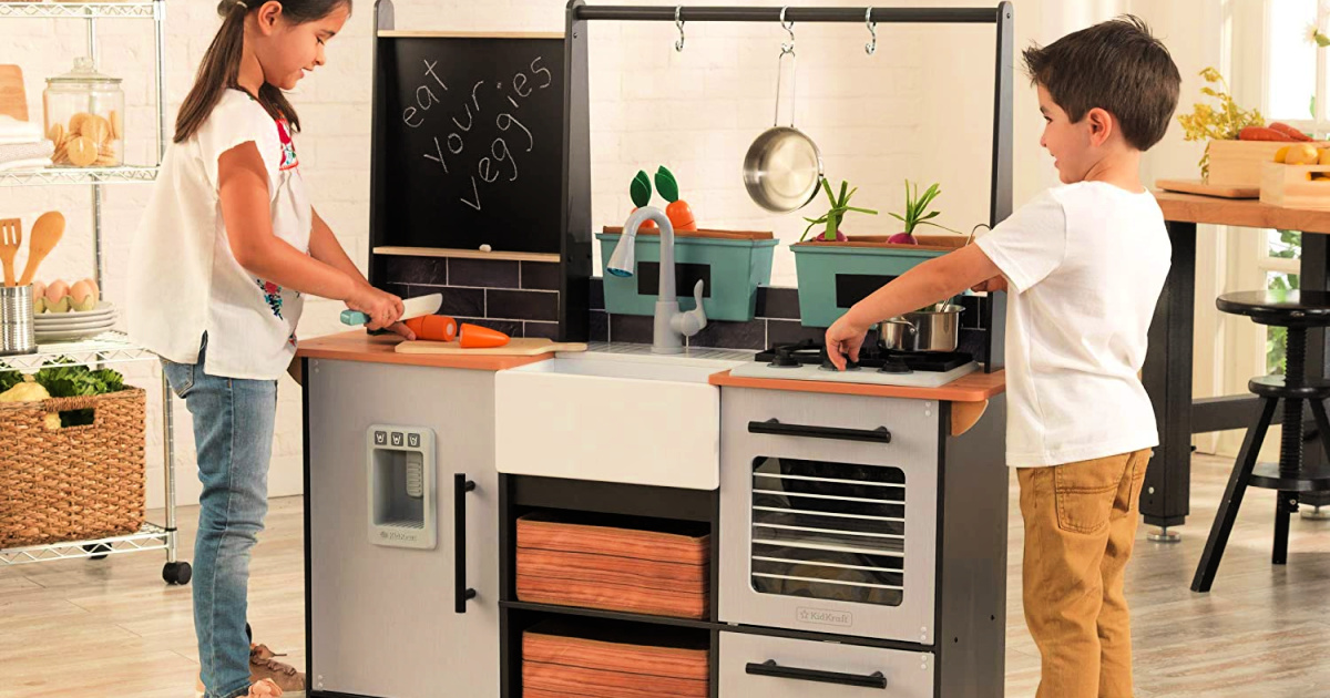 a girl and boy playing with the KidKraft Wooden Farm to Table Play Kitchen