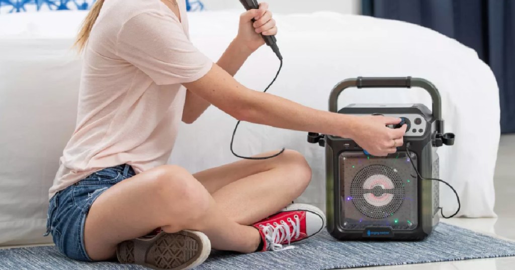 girl sitting on floor in front of karaoke machine 