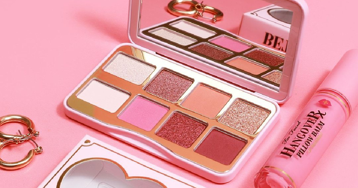 open makeup palette on display against a pink background