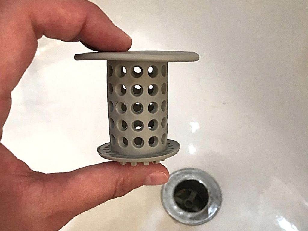 hand holding gray drain stopper