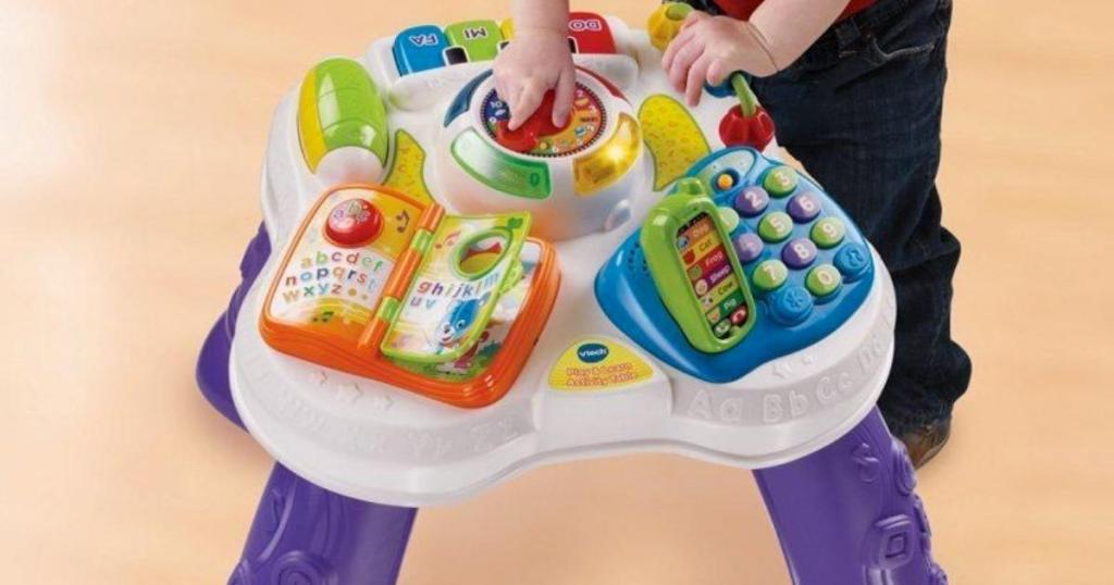 child playing with vtech sit to stand learn and discover table