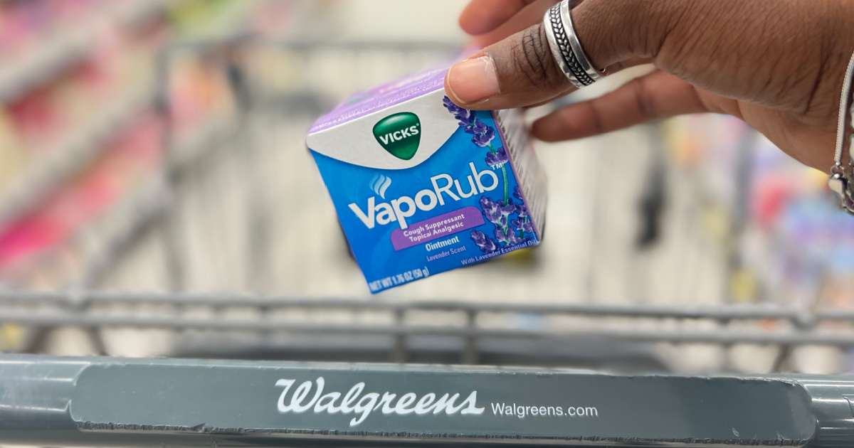 hand holding cough suppressant ointment above store cart