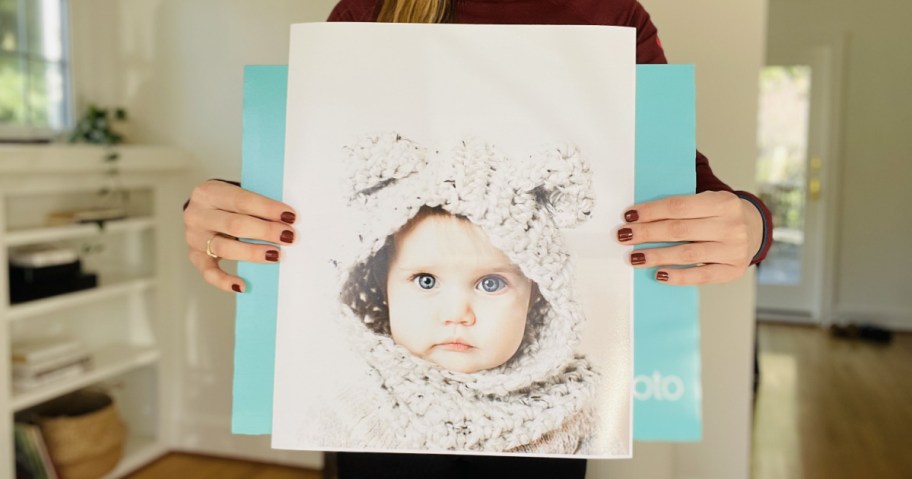 woman holding large poster print from Wallgreens