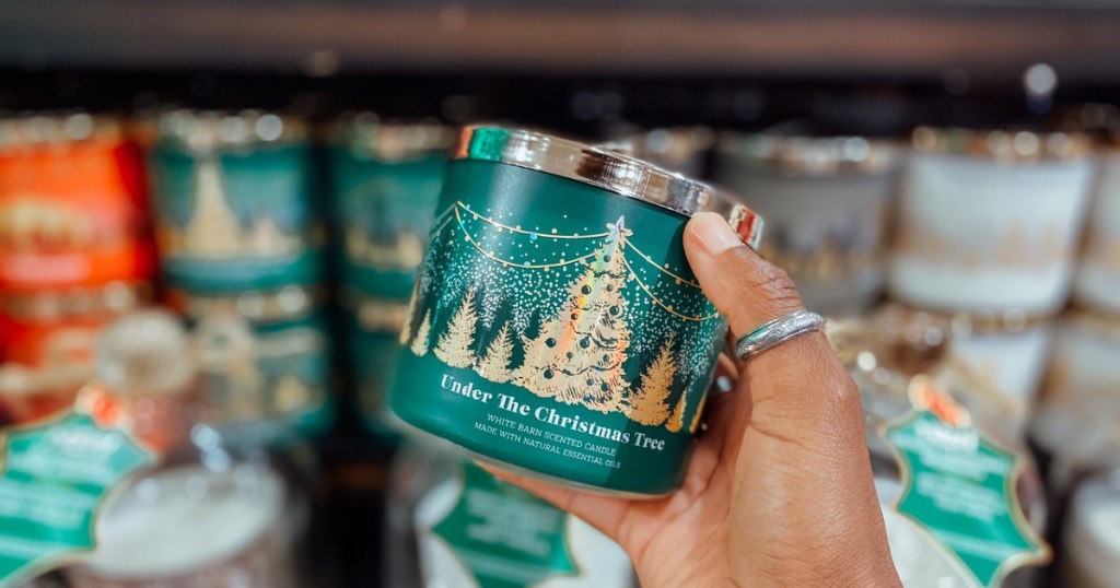 woman holding a green christmas candle jar