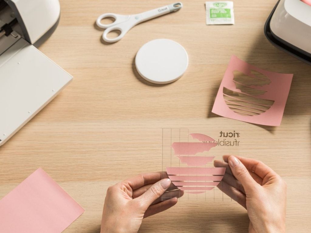 woman holding up cricut design for coaster