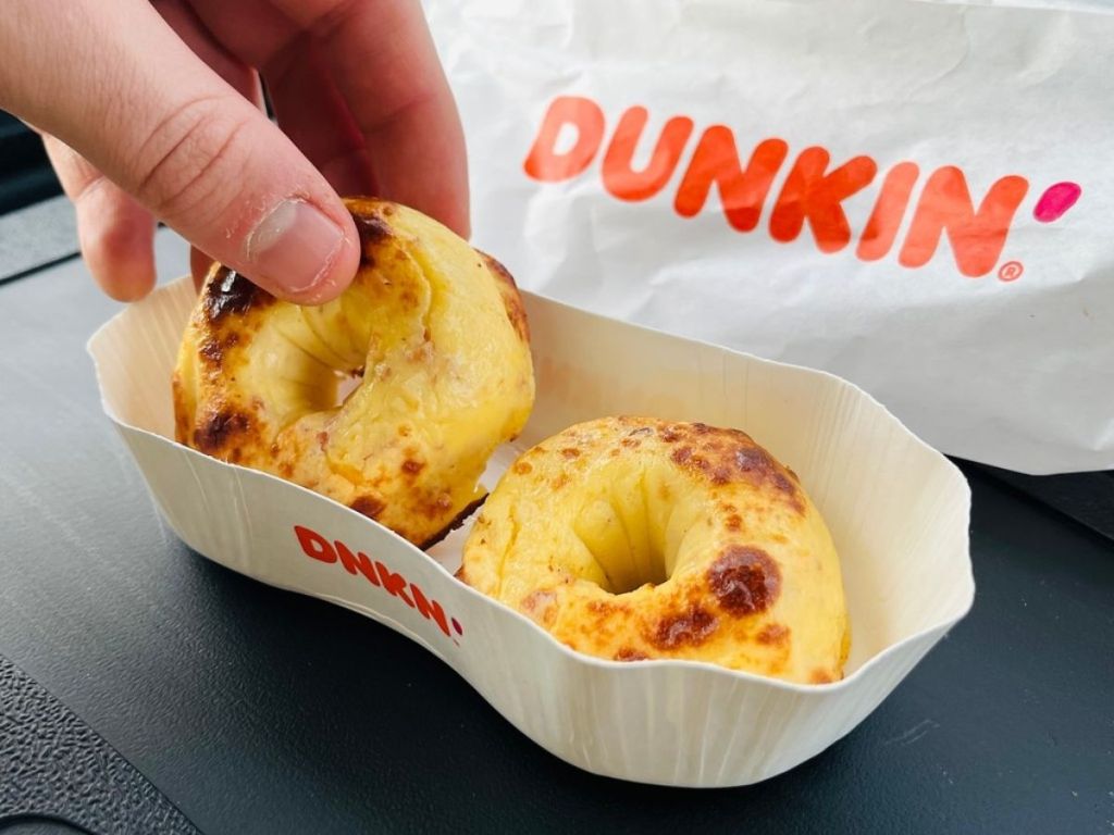 hand lifting dunkin omelet bites out of a container