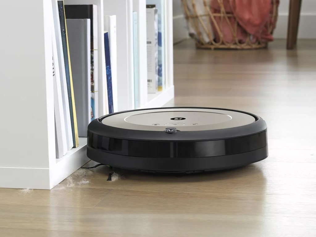 robot vacuum next to bookshelf