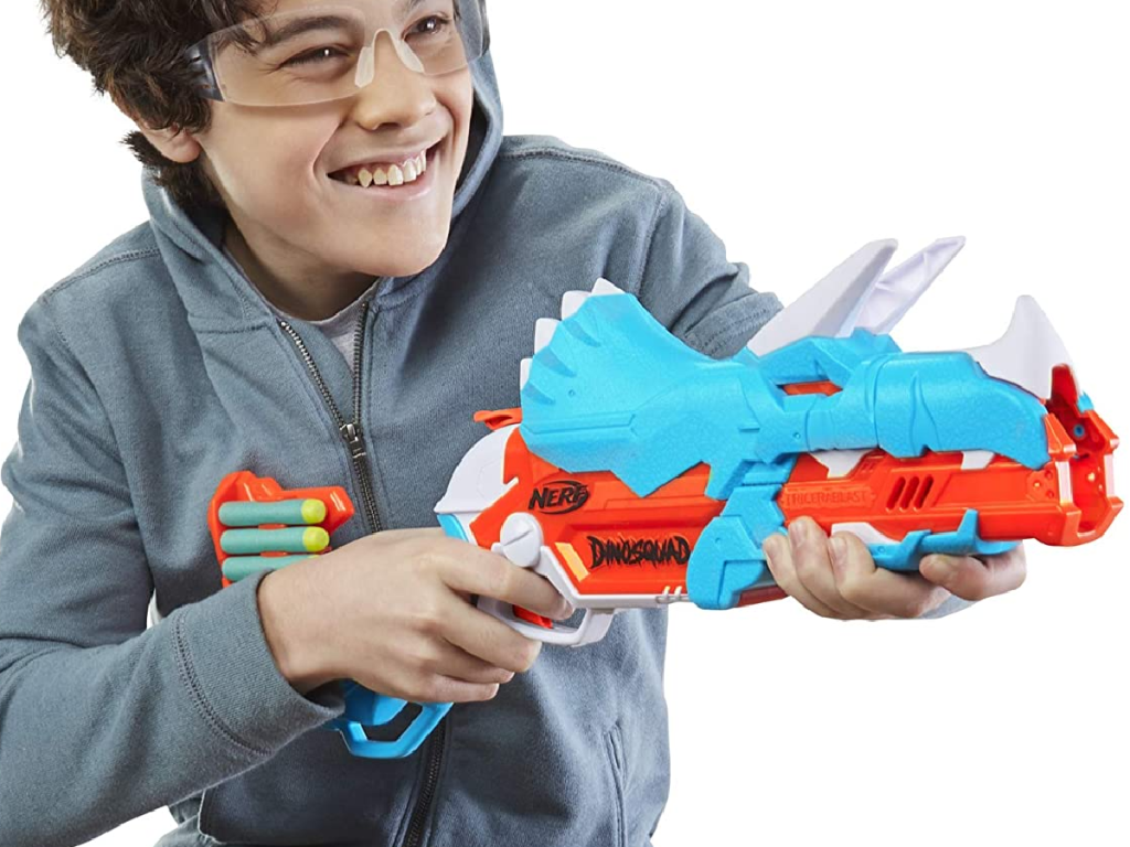 kid holding nerf gun shaped like a dinosaur