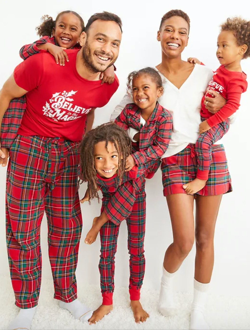 family posing and happy wearing red matching christmas pajamas