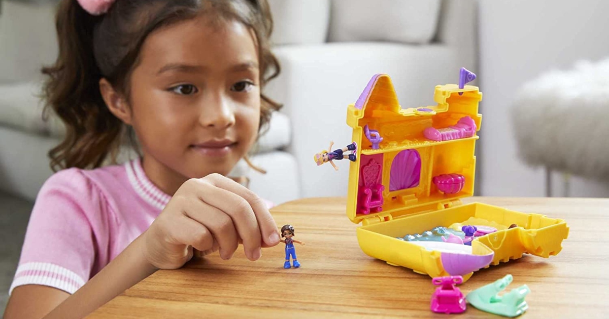 girl playing at a table with a Polly Pocket set